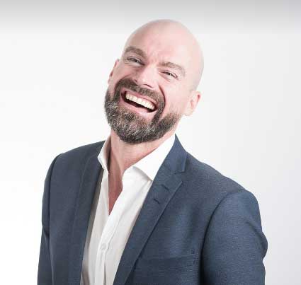Benjamin Clarke, un hombre calvo, sonriendo y mirando hacia el cielo, expresando satisfacción y felicidad como un cliente satisfecho.