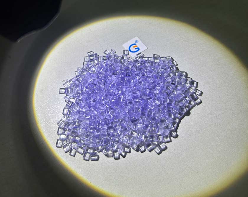 Gránulos UV brillando en morado pálido bajo la iluminación de una linterna